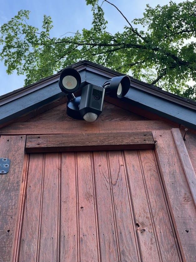 Black Ring floodlight camera mounted on a cedar gable peak